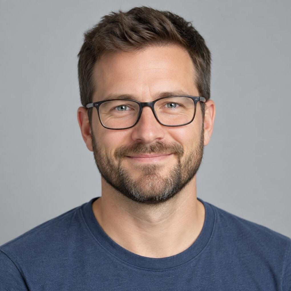 Studio portrait of a smiling white man with glasses